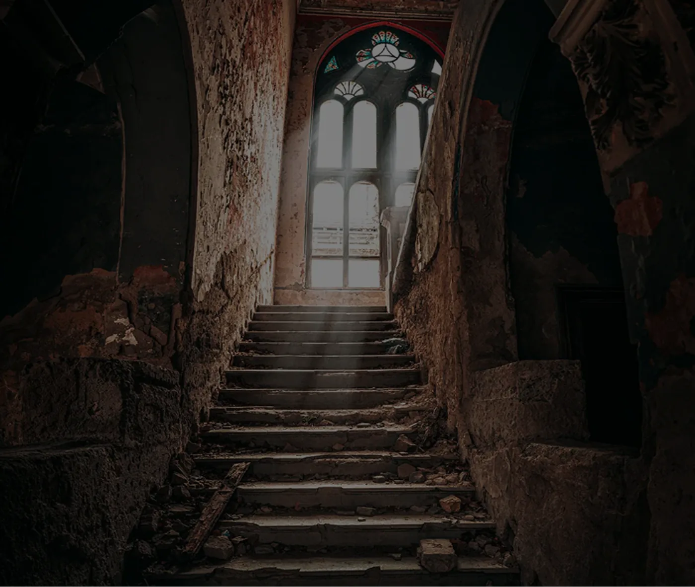 An old stone staircase rising toward an arch full of daylight